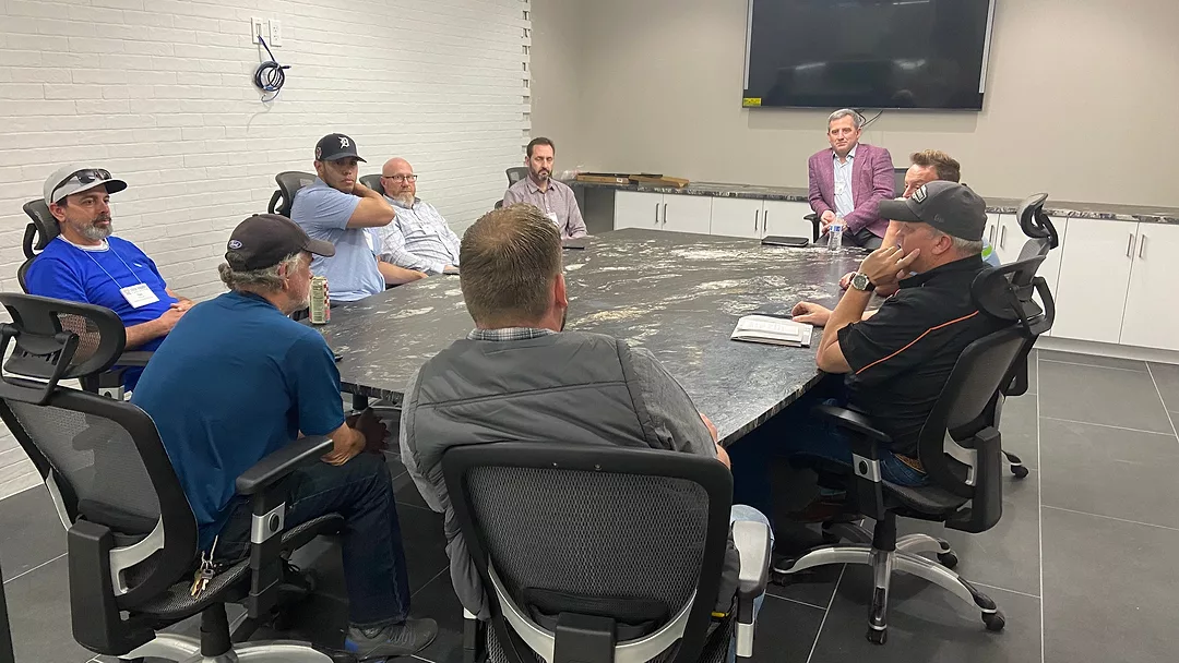 Small breakout group discussing business strategies at Stone Industry Education event