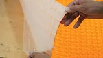 Schluter Peel-and-Stick uncoupling membrane being pulled apart.