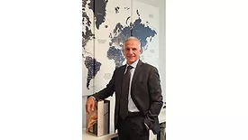 Michele Ballarin Standing by World Map on Wall
