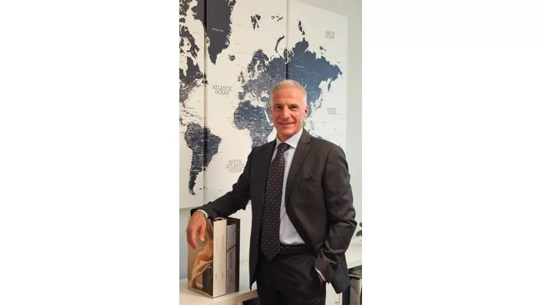 Michele Ballarin Standing by World Map on Wall