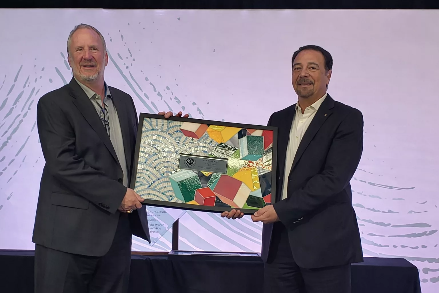 Bart Bettiga and Luigi di Geso holding the president's award mosaic
