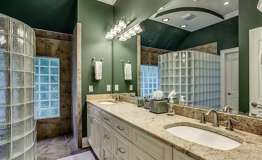 The latter bathroom was dark and outdated, with a glass block shower, which was revived with a timeless design.
