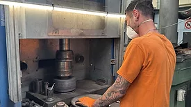 a worker operating a hydraulic press